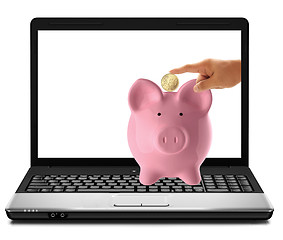 Image showing hand inserting a coin into a laptop