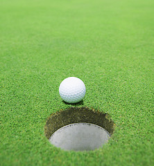 Image showing The ball at the hole on the golf course