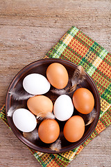 Image showing eggs in a plate, towel and feathers 