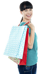 Image showing Girl with shopping bags tossed over her shoulders