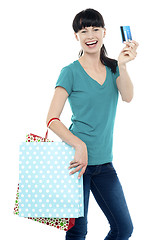 Image showing Shopaholic woman holding her cash card up