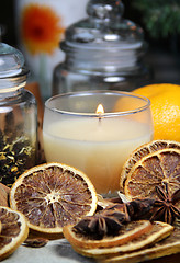 Image showing Candle, cinnamon sticks and dry orange