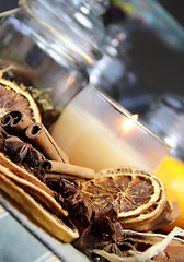 Image showing Candle, cinnamon sticks and dry orange