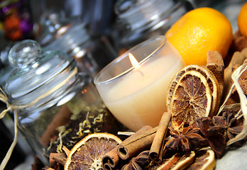 Image showing Candle, cinnamon sticks and dry orange