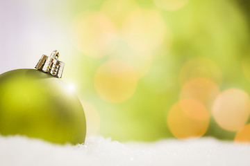 Image showing Green Christmas Ornaments on Snow Over an Abstract Background