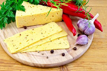 Image showing Cheese with spices and herbs on a round board