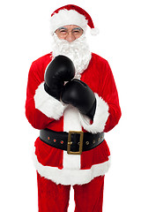 Image showing Aged cheerful Santa wearing boxing gloves