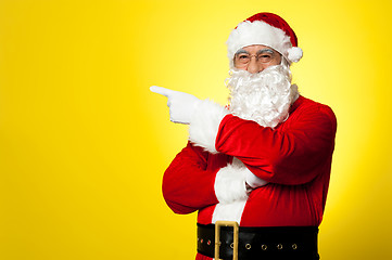 Image showing Kris Kringle gesturing towards the copy space area