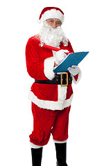 Image showing Santa Claus making list of gift recipients