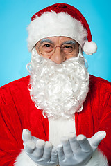 Image showing Smiling aged Santa posing with open palms