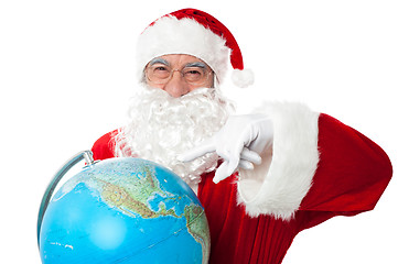 Image showing Expressionistic Santa pointing at north pole on globe