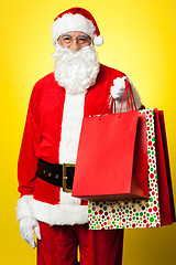 Image showing Joyous Santa posing with colorful shopping bags