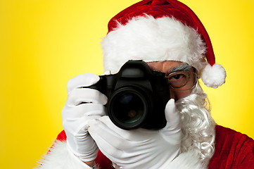 Image showing Aged Santa adjusting camera lens before click