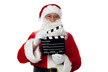 Image showing Cheerful aged Santa posing with a clapperboard