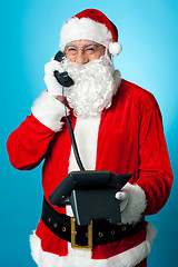 Image showing Modern Santa passing greetings over a phone call