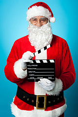 Image showing Bespectacled Santa holding a clapperboard