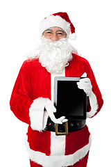 Image showing Old man in santa costume posing with a tablet pc