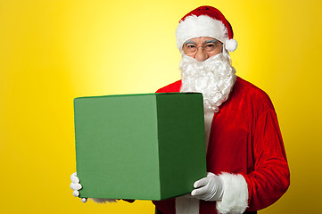 Image showing Santa Claus delivering big green gift box