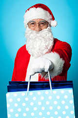 Image showing Santa holding shopping bags in his outstretched arms