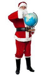 Image showing Santa pointing out a continent on globe