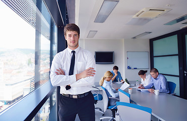 Image showing business man  on a meeting in offce with colleagues in backgroun