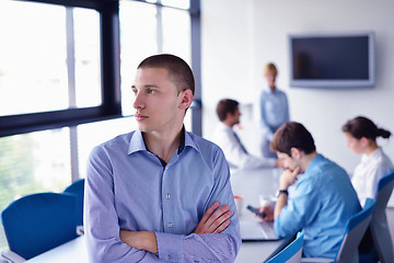 Image showing business man  on a meeting in offce with colleagues in backgroun