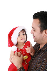 Image showing Father and daughter looking happy wearing santa Christmas hat.  