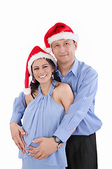 Image showing A beautiful young hispanic couple wearing Christmas Santa Hats