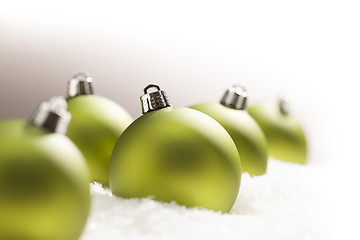 Image showing Green Christmas Ornaments on Snow Over a Grey Background