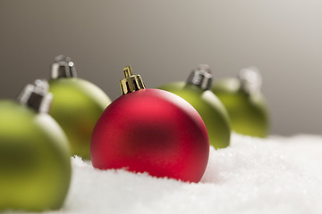 Image showing Red and Green Christmas Ornaments on Snow Over Grey