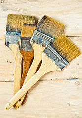 Image showing Old paint brushes on wooden background