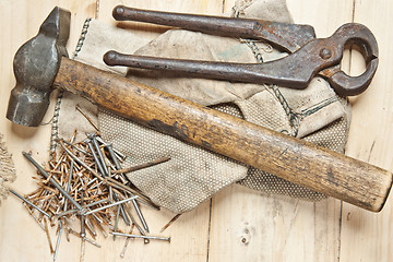 Image showing Vintage hammer with nails on wood background