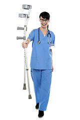 Image showing Orthopedic doctor walking towards camera with crutches in hand
