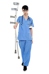 Image showing Sad doctor holding up crutches in hand