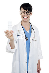 Image showing Bespectacled duty doctor showing medicine strip