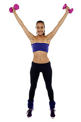 Image showing Strong woman lifting the dumbbells high in the air