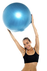 Image showing woman holding big blue pilates ball above her head