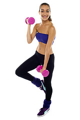 Image showing Slim young woman working out with dumbbells