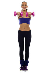 Image showing Woman holding pink dumbbells in her outstretched arms