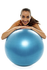 Image showing Woman leaning over big blue swiss ball