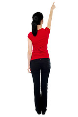 Image showing Back pose of woman in casuals pointing away