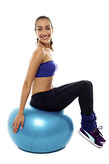 Image showing Pretty lady sitting on big blue exercise ball