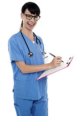 Image showing Medical nurse jotting down notes on writing pad