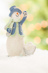 Image showing Snowman Statue On Snow Over a Blurry Abstract Background