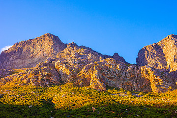 Image showing Orange-lit cliffs and blue sky