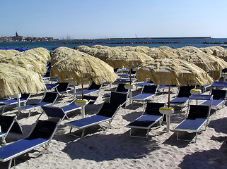 Image showing Straw umbrellas and chairs on beach