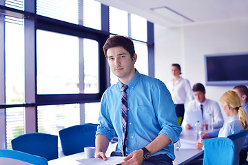 Image showing business man  on a meeting in offce with colleagues in backgroun