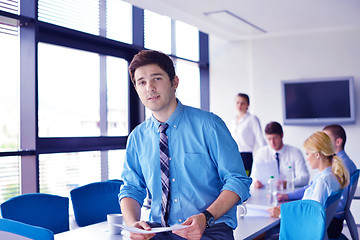 Image showing business man  on a meeting in offce with colleagues in backgroun