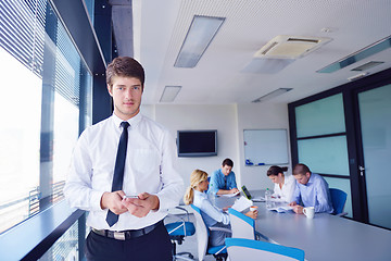 Image showing business man  on a meeting in offce with colleagues in backgroun