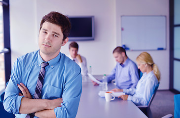 Image showing business man  on a meeting in offce with colleagues in backgroun